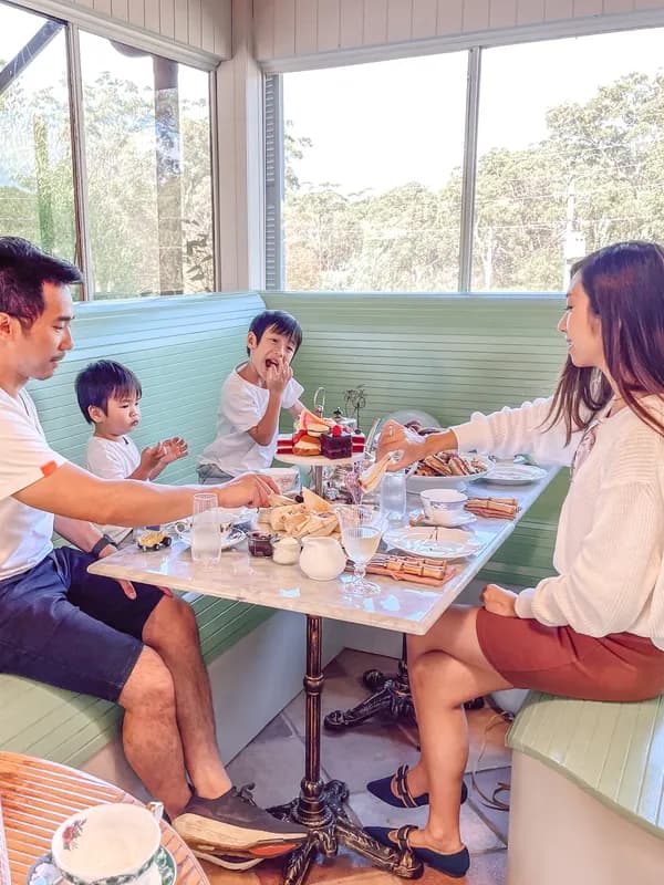A family sharing a meal at a sunny restaurant booth